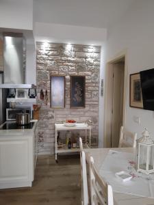 a kitchen and dining room with a stone wall at Vogklis House in Qeparo