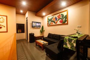 a living room with a couch and a table at Villa Favore in Puncak