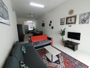 a living room with a couch and a tv at Lynn Homestay Alor Setar in Alor Setar