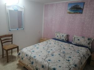 a bedroom with a bed and a chair and a window at Studio Yakina in El Haouaria +43 photos