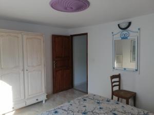 a bedroom with a bed and a closet and a mirror at Studio Yakina in El Haouaria