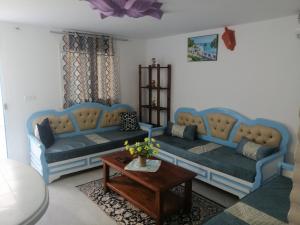 a living room with two couches and a table at Studio Yakina in El Haouaria