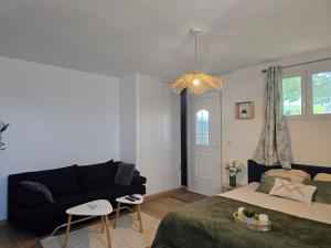a living room with a couch and a bed at Appartement le Tilleul - Apparts Cosy in Saint-Pons