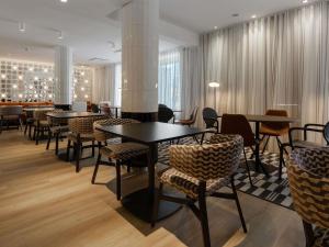 a restaurant with tables and chairs in a room at ibis Styles Tallinn in Tallinn