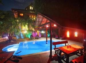 een zwembad met een tafel naast een huis bij 7 Bedroom Seafront Villa Phanghan SDV232-By Samui Dream Villas in Srithanu