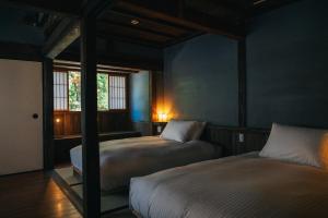 ein Schlafzimmer mit zwei Betten und einem großen Spiegel in der Unterkunft Hotel Raccan in Shibushi
