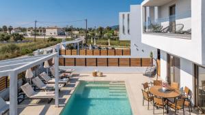 a balcony with a pool and patio furniture and a table and chairs at Villa Lux Stana in Zakynthos
