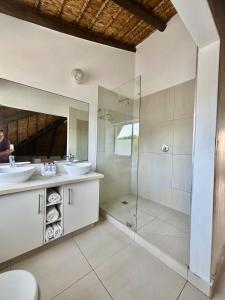 a bathroom with two sinks and a shower at i-LOLLO Bed & Breakfast at the River Mouth in St Francis Bay +43 photos