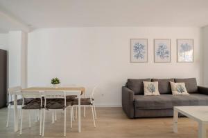 a living room with a table and a couch at Ático puerto Burriana in Burriana