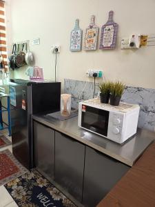 a microwave sitting on a counter in a kitchen at Lynn Homestay Alor Setar in Alor Setar