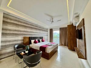 a bedroom with a bed and a table and chairs at Soothing Stayz - Near Medanta The Medicity in Gurgaon