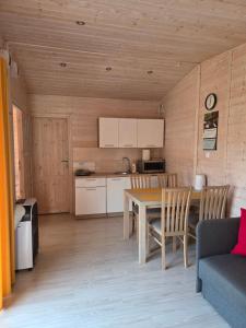 a kitchen and living room with a table and a couch at Zacisze in Józefów