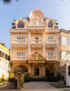 a large building with an archway in front of it at Peach Valley Hotel Dalat in Da Lat