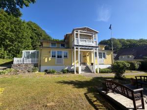 a yellow house with a balcony on top of it at Waldhaus Sellin in Ostseebad Sellin
