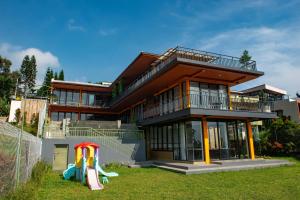 a house with a playground in front of it at Villa Favore in Puncak