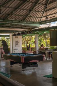 a pool table in a room with people sitting at tables at URALSURF HOUSE in Weligama
