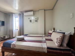 a bedroom with two beds with pillows on it at ZM Residence in Dapa