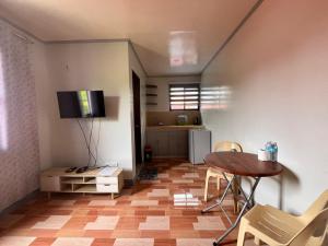 a living room with a table and a television on the wall at ZM Residence in Dapa