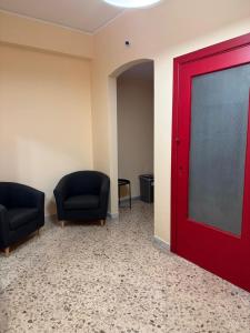 a room with two chairs and a red door at Pompei Sanctuary rooms in Pompei