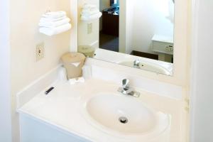 a white bathroom with a sink and a mirror at Boardman in McKays Corners