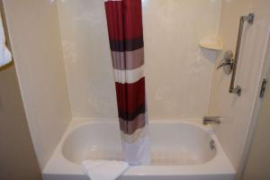 a shower with a red and white shower curtain in a bathroom at Boardman in McKays Corners