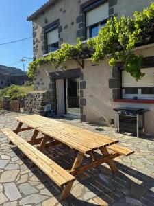 a wooden picnic table in front of a building at Chez Albert, in Saint-Ilpize