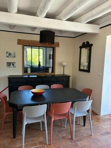 a dining room with a black table and chairs at Chez Albert, in Saint-Ilpize