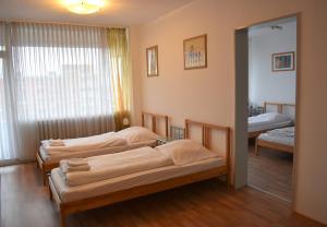 three beds in a room with a mirror at Work & stay Neuss in Neuss
