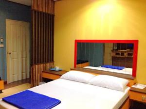 a bedroom with a large bed and a mirror at Zigzag Resort in Yasothon