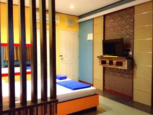 a room with two beds with a fireplace and a tv at Zigzag Resort in Yasothon