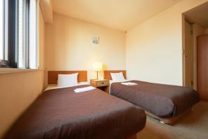 a hotel room with two beds and a window at Hotel Select Inn Hachinohe Chuo in Hachinohe