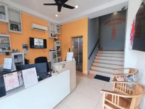 a restaurant with a counter and two chairs at One World Lodging in Bentong