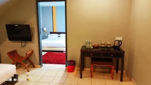 a room with a table and a bed and a mirror at One World Lodging in Bentong