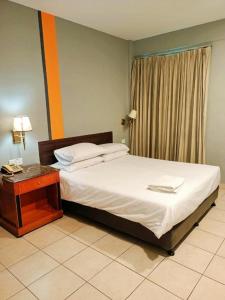 a bedroom with a bed with a desk and a window at One World Lodging in Bentong