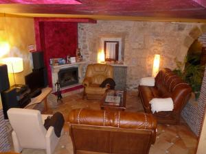 a living room with a leather couch and a fireplace at Posada El Pozo in Castanedo