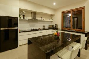 eine Küche mit einer schwarzen Arbeitsplatte und einem schwarzen Kühlschrank in der Unterkunft Villa Ley Seminyak by Best Deals Asia Hospitality in Seminyak