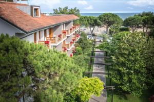 Vistas al mar de un edificio con árboles y una carretera en Hotel Capanna d'Oro, en Lignano Sabbiadoro