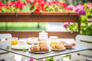 a table topped with plates of breakfast foods and orange juice at Hotel Capanna d'Oro in Lignano Sabbiadoro