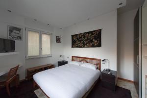 1 dormitorio con cama blanca, escritorio y ventana en B&B Rosa Blu, en Como