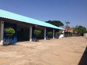 a building with a blue roof with potted trees in front at My House in Surin