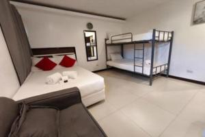 a bedroom with a bed and bunk beds in it at Ecoland 88 Apartelle and Suite near SM Davao in Davao City +53 photos