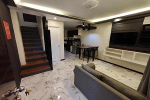 a living room with a couch and a flat screen tv at Ecoland 88 Apartelle and Suite near SM Davao in Davao City