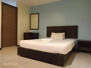 a bedroom with a large bed with white sheets at BB Motel in Alor Setar