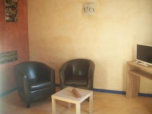 two black leather chairs and a table in a room at Studios et chambre La Sauvasse in Vagnas