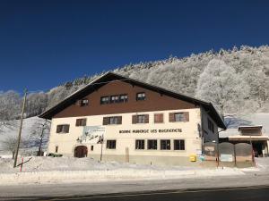 a large building on the side of a snow covered mountain at Bonne Auberge Les Bugnenets in Le Paquier