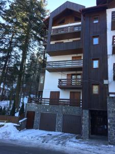 een appartementencomplex met sneeuw op de grond bij Muller Apartment in Sinaia