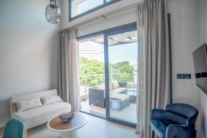 a living room with a couch and a sliding glass door at Evaeri Suites in Mytikas