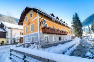 ein großes Gebäude mit Balkon im Schnee in der Unterkunft Gasthof zum Hammer in Göstling an der Ybbs