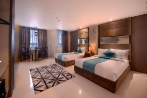 a hotel room with two beds and a table at Hotel Estrella in Tacloban +40 photos