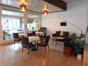 Park Hotel في كاستيل سان بييترو تيرمي: غرفة معيشة مع أريكة وطاولات وكراسي